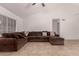 Bright living room featuring a vaulted ceiling, tile floors and a comfortable brown sectional couch at 6038 W Gelding Dr, Glendale, AZ 85306