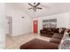 Bright living room featuring tile floors, a vaulted ceiling, a red front door and a comfortable brown sectional couch at 6038 W Gelding Dr, Glendale, AZ 85306
