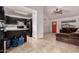 Open concept kitchen/living area featuring tile floors, dark cabinetry, a red front door and a comfortable brown sectional couch at 6038 W Gelding Dr, Glendale, AZ 85306