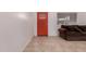 Cozy living room featuring a red front door, tile floors, and a comfortable-looking brown sectional at 6038 W Gelding Dr, Glendale, AZ 85306