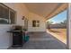Covered patio with grill, offering a great outdoor space with access to a grassy backyard at 6038 W Gelding Dr, Glendale, AZ 85306