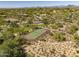 Aerial perspective of a residential area, highlighting the tennis court amenity and the surrounding desert landscape at 6621 E Oberlin Way, Scottsdale, AZ 85266