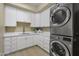 Well-organized laundry room with ample white cabinetry, sleek countertops, and modern washer/dryer units at 6621 E Oberlin Way, Scottsdale, AZ 85266