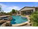 Beautiful backyard featuring a custom swimming pool, spa, covered patio, and outdoor kitchen area at 6621 E Oberlin Way, Scottsdale, AZ 85266