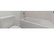 Bathroom with a white tub, stylish tile surround, and modern fixtures at 7420 S 76Th Ln, Laveen, AZ 85339
