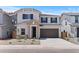 Charming two-story home featuring a stone entrance, dark shutters, and a spacious two-car garage at 7420 S 76Th Ln, Laveen, AZ 85339
