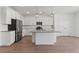 Bright kitchen features white cabinetry, stainless steel appliances, a large island, and wood-look tile floors at 7420 S 76Th Ln, Laveen, AZ 85339
