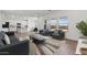 Open-concept living room featuring modern furniture, wood-look tile flooring, and natural light at 7420 S 76Th Ln, Laveen, AZ 85339