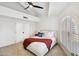 Bedroom features a large window, a ceiling fan and a red blanket on the bed at 8405 E San Pedro Dr, Scottsdale, AZ 85258