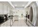 Bright kitchen with stainless steel appliances, white cabinets, black countertops, and neutral tile flooring at 8405 E San Pedro Dr, Scottsdale, AZ 85258