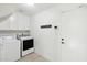 Bright laundry room with modern washer and dryer, ample shelving, and convenient access to the door at 8405 E San Pedro Dr, Scottsdale, AZ 85258