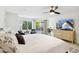 Bright main bedroom features a ceiling fan, outdoor access, and television at 8405 E San Pedro Dr, Scottsdale, AZ 85258