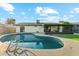 Enjoy the beautiful pool and patio area, set against the green grass and blue skies at 8701 E Sage Dr, Scottsdale, AZ 85250