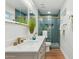 Beautiful bathroom featuring double sinks, blue tiled shower with glass door, and modern fixtures at 8701 E Sage Dr, Scottsdale, AZ 85250