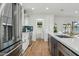 Spacious kitchen with stainless steel appliances, white cabinetry, and a center island with bar seating at 8701 E Sage Dr, Scottsdale, AZ 85250
