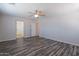Open bedroom with wood-look floors, ceiling fan, and two open doorways at 900 E Harrison St, Chandler, AZ 85225