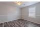 An empty bedroom with wood-look floors, a ceiling fan, and a window at 900 E Harrison St, Chandler, AZ 85225