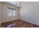 A vacant bedroom features wood-look floors, a ceiling fan, and a window at 900 E Harrison St, Chandler, AZ 85225