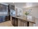 Kitchen island featuring a stainless steel sink and appliances, granite countertops, and dark cabinets at 900 E Harrison St, Chandler, AZ 85225