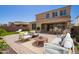 Stunning backyard with stone patio, outdoor seating, lush landscaping, and seamless indoor-outdoor living at 9764 E Radioactive Dr, Mesa, AZ 85212