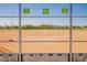 A baseball field behind a chainlink fence, with signage indicating rules and field number at 9764 E Radioactive Dr, Mesa, AZ 85212