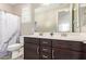 Bathroom featuring a double vanity with marble counters, dark cabinets and a shower tub combo at 9764 E Radioactive Dr, Mesa, AZ 85212
