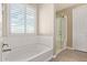 Bright bathroom showcases a soaking tub, glass enclosed shower, and a shuttered window at 9764 E Radioactive Dr, Mesa, AZ 85212