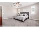Comfortable bedroom with a ceiling fan, carpet, and a queen bed with grey upholstered headboard at 9764 E Radioactive Dr, Mesa, AZ 85212