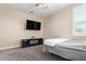 Cozy bedroom featuring plush carpet, a modern TV stand, and a bright window with blinds at 9764 E Radioactive Dr, Mesa, AZ 85212