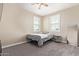 Bedroom with neutral walls, carpet, ceiling fan, two windows with closed white shutters, and a single bed at 9764 E Radioactive Dr, Mesa, AZ 85212