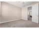 Bedroom with neutral walls, carpet, ceiling fan, and an open door to the hall at 9764 E Radioactive Dr, Mesa, AZ 85212