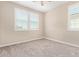 Bedroom with neutral walls, carpet, ceiling fan, and two windows with closed white shutters at 9764 E Radioactive Dr, Mesa, AZ 85212