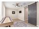 Entertainment room featuring a shuffleboard table, ceiling fan, gray sliding door, and ample space at 9764 E Radioactive Dr, Mesa, AZ 85212