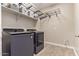 Well-equipped laundry room with modern washer and dryer, shelving for storage, and tile flooring at 9764 E Radioactive Dr, Mesa, AZ 85212