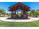 Open-air picnic gazebo structure surrounded by grassy area, and other trees on a sunny day at 9764 E Radioactive Dr, Mesa, AZ 85212