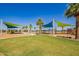 Playground with vibrant shade structures, swings, and play equipment on a sunny day at 9764 E Radioactive Dr, Mesa, AZ 85212