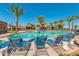 Resort-style pool and lounge chairs on sunny day with palm trees and a basketball hoop in pool at 9764 E Radioactive Dr, Mesa, AZ 85212