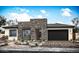 Contemporary single-story home featuring stone accents, a two-car garage, and desert landscaping at 9775 S 36Th Ln, Laveen, AZ 85339