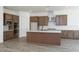 Spacious kitchen boasts wood cabinets, an island, stainless steel appliances, and tiled backsplash at 9775 S 36Th Ln, Laveen, AZ 85339
