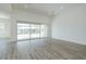 Bright, open living room with wood-look tile flooring and a large sliding glass door to the backyard at 9775 S 36Th Ln, Laveen, AZ 85339