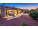 This cozy backyard features a covered patio, swing, desert landscaping, and soft outdoor lighting at 12928 W Santa Ynez Dr, Sun City West, AZ 85375