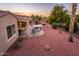 This backyard features a covered patio with comfortable seating, desert landscaping, and views of the golf course at 12928 W Santa Ynez Dr, Sun City West, AZ 85375