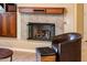 Cozy fireplace with decorative mantel, complemented by a comfortable chair and ottoman at 12928 W Santa Ynez Dr, Sun City West, AZ 85375
