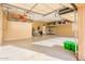 Spacious and organized garage featuring overhead racks, storage cabinets, and epoxy flooring at 12928 W Santa Ynez Dr, Sun City West, AZ 85375