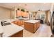 Spacious kitchen with wooden cabinetry, granite countertops, island, and breakfast nook at 12928 W Santa Ynez Dr, Sun City West, AZ 85375