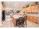 Large kitchen with an island, breakfast bar, wood cabinets, and tiled backsplash at 12928 W Santa Ynez Dr, Sun City West, AZ 85375