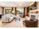 Comfortable living room featuring a fireplace, a large TV, and plenty of natural light at 12928 W Santa Ynez Dr, Sun City West, AZ 85375