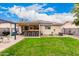 Large backyard features covered outdoor seating and a bar area, solar panels, and lush green grass at 13359 W Post Dr, Surprise, AZ 85374