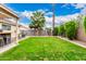 Beautiful green backyard with a covered outdoor kitchen area, nice landscaping and privacy at 13359 W Post Dr, Surprise, AZ 85374