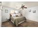This bedroom boasts ample natural light, a cozy bed, a ceiling fan, and well-coordinated decor at 13359 W Post Dr, Surprise, AZ 85374